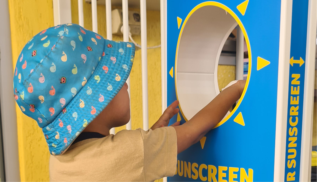 Young child using sunsquirt machine